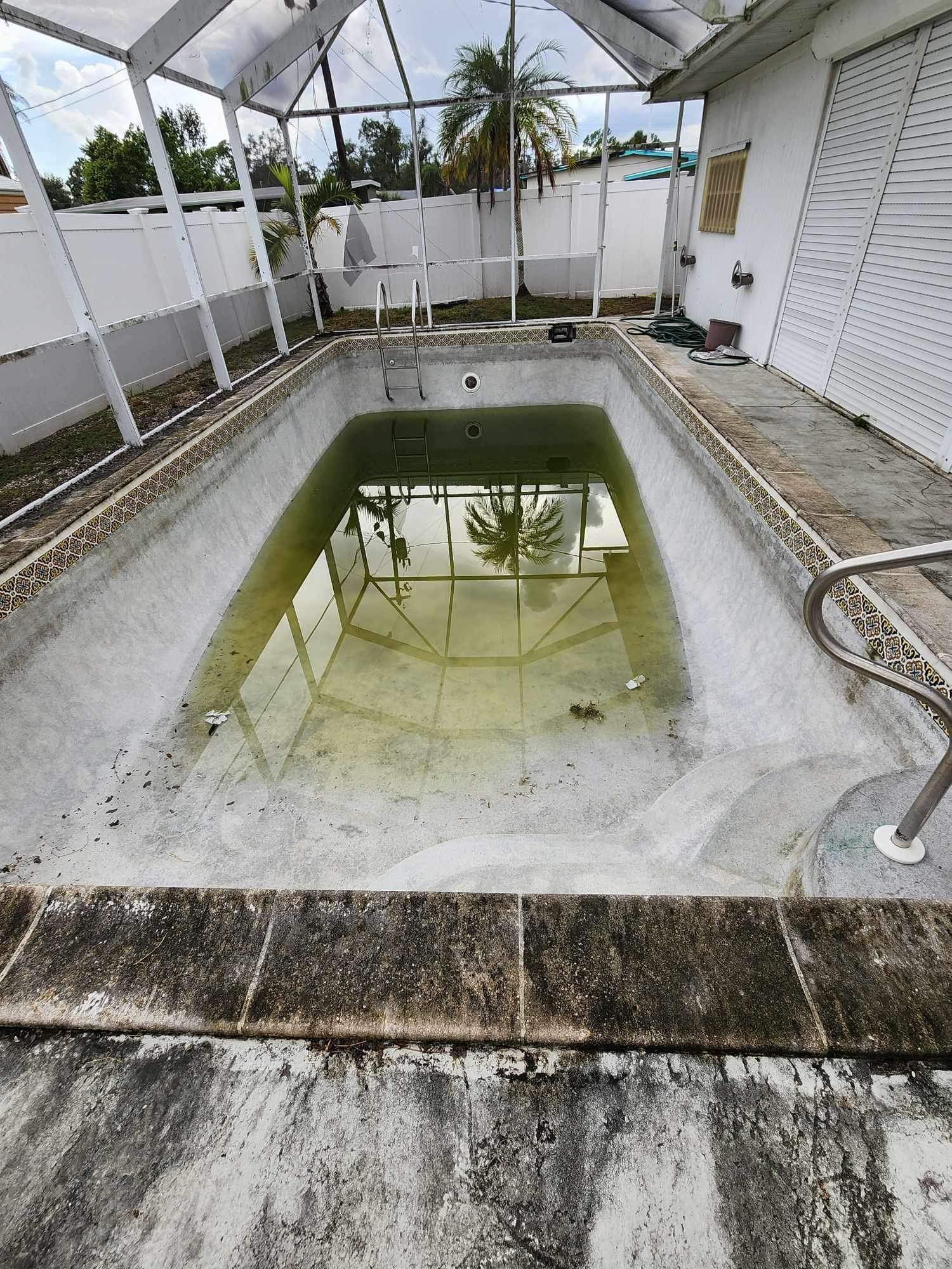 An empty swimming pool with a lot of water in it.