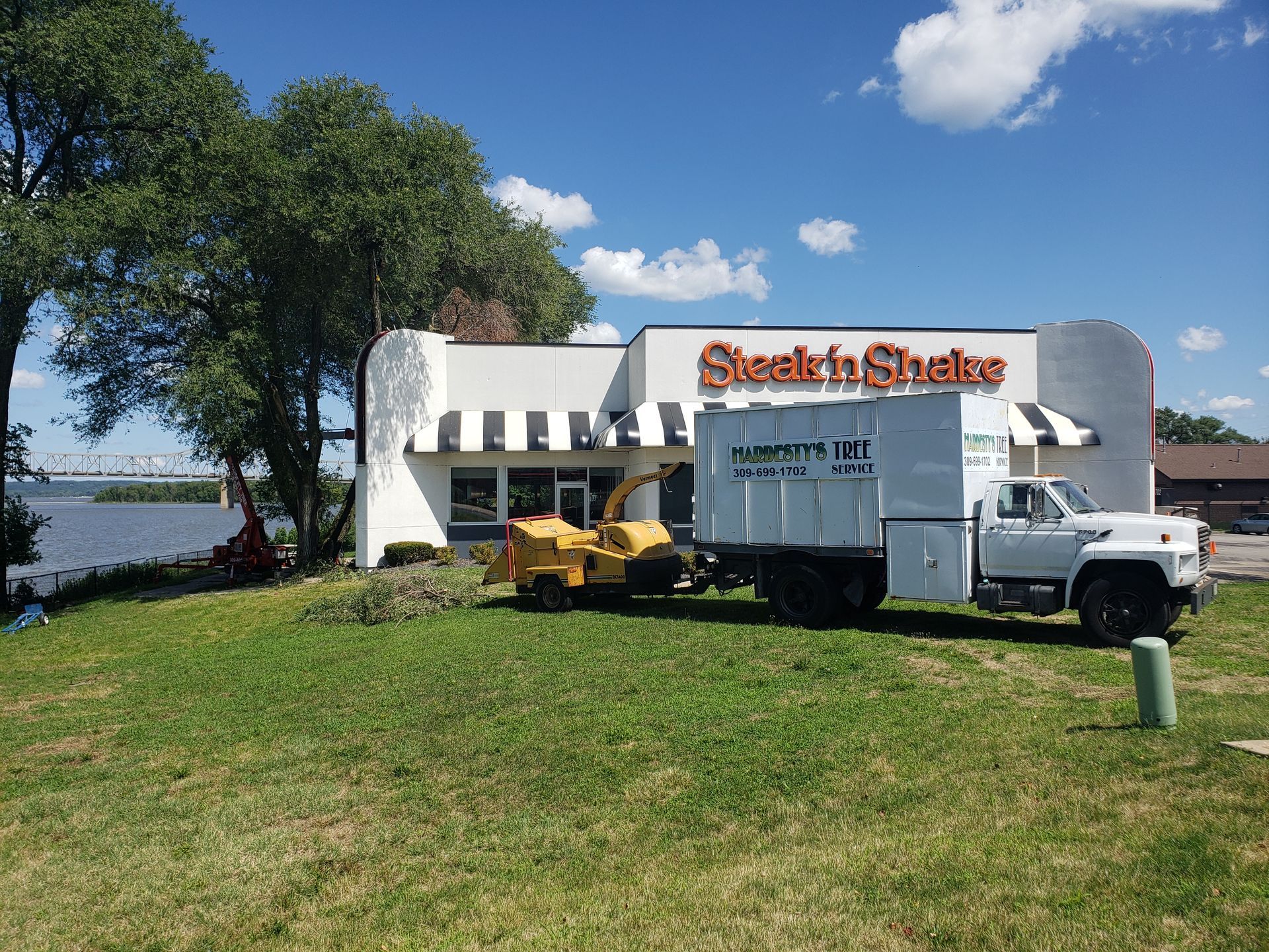 A truck is parked in front of a steak n shake restaurant.