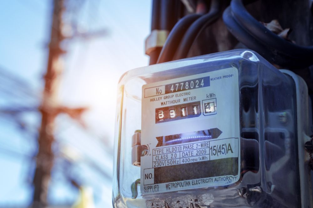 Utility Meter Displaying Numbers. Wires and a Pole Are Visible in the Background, Blue Sky — Holders Electrical In Stanthorpe, QLD