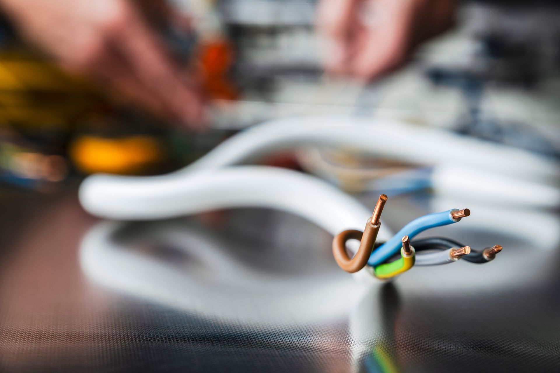 Close Up of White Electrical Cable With Exposed Wires; Person in Background  — Holders Electrical In Tenterfield, NSW 