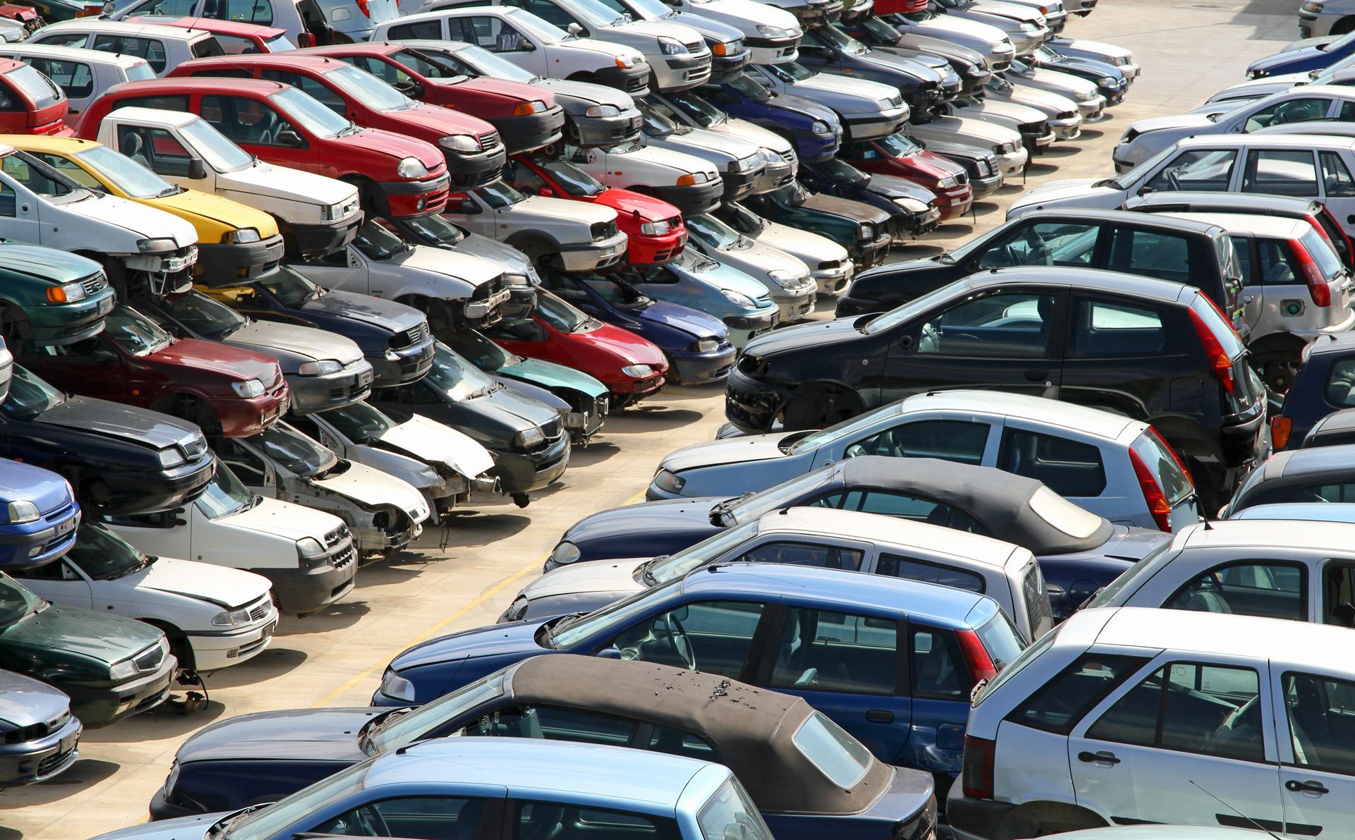 Rows of parked cars in a crowded outdoor lot, viewed from above.