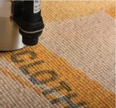 A machine is printing the word good on a carpet.