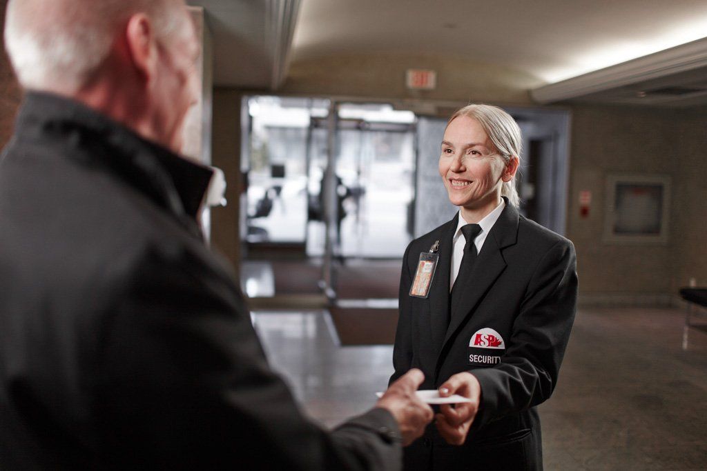 A woman in a suit is giving a man a business card.