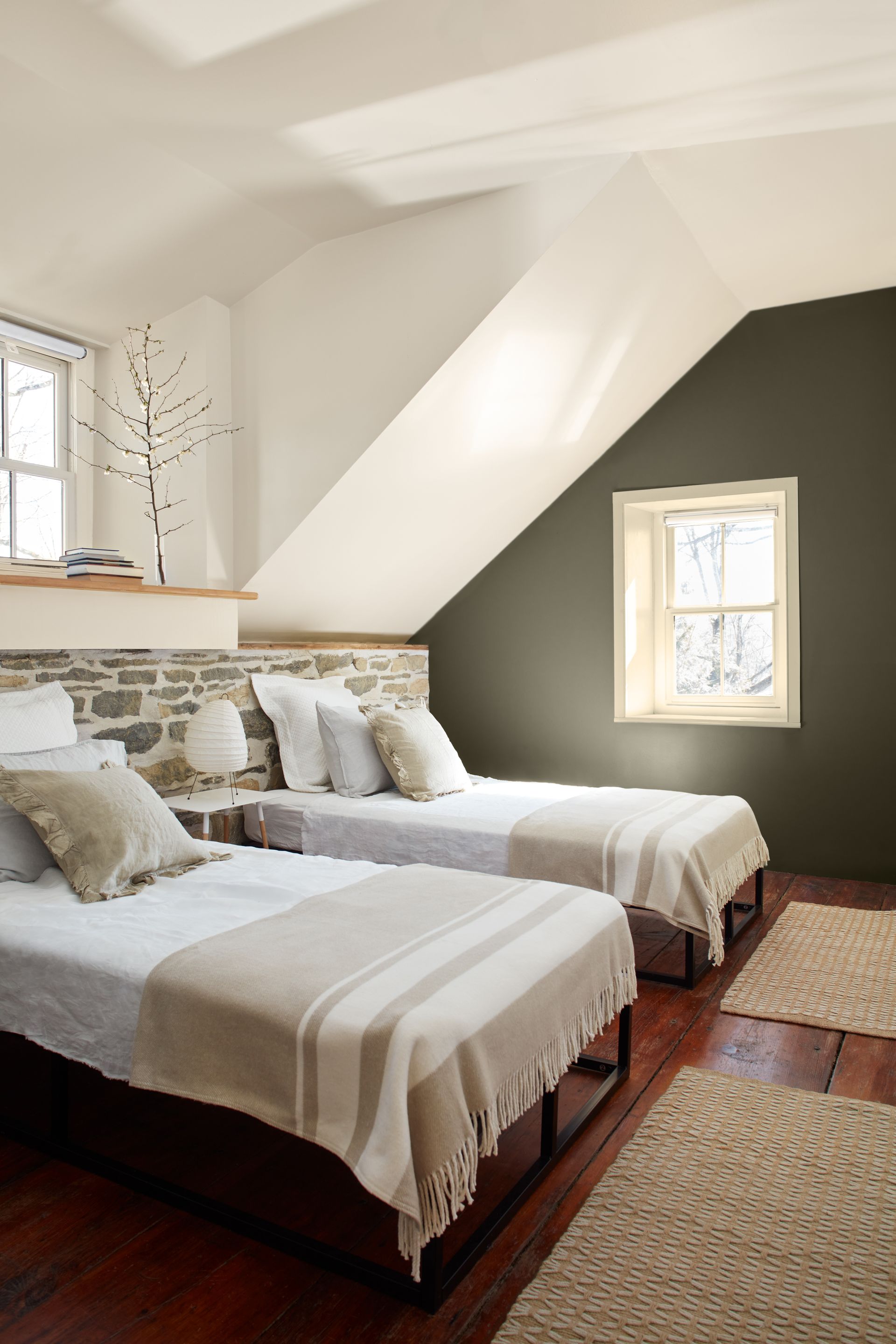 A bedroom with two twin beds and a window.