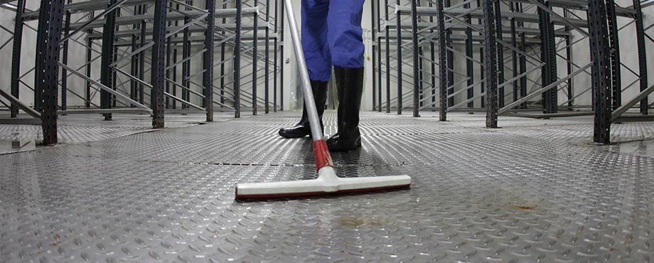 a cleaner cleaning a factory floor 