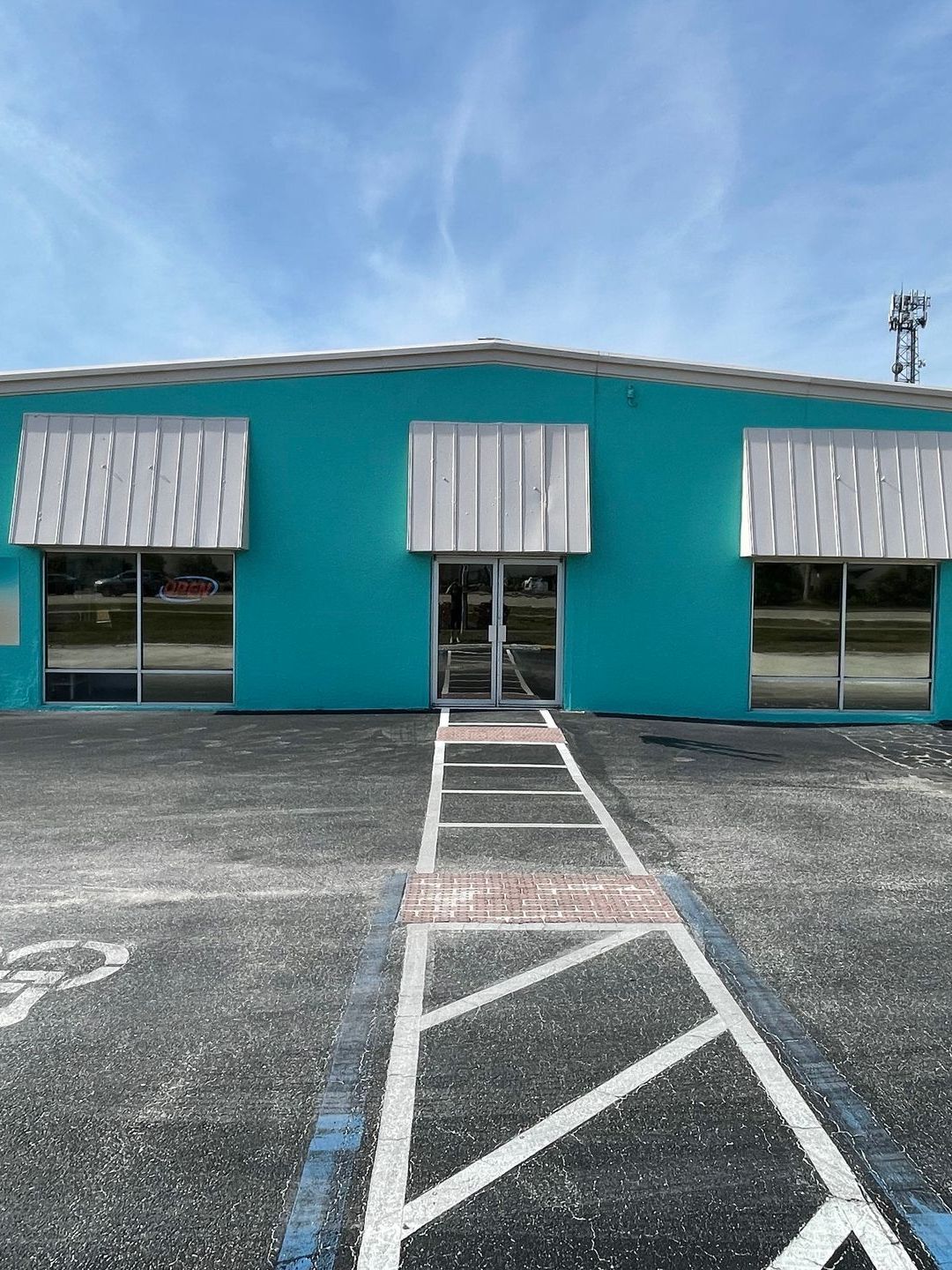 A blue building with a handicapped parking space in front of it.