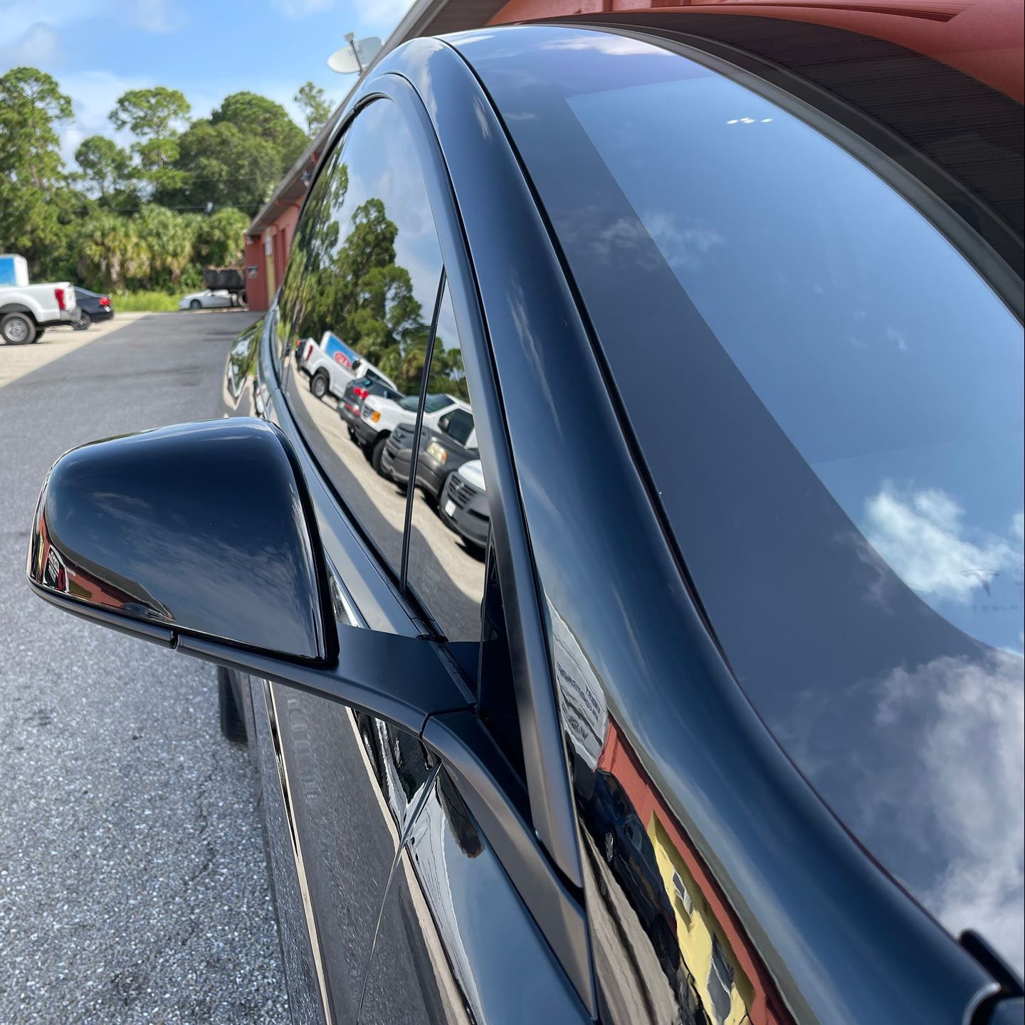 A black car is parked on the side of the road