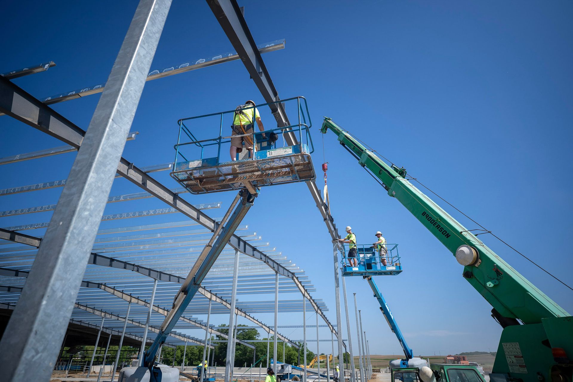 guys in cranes building steel frame building