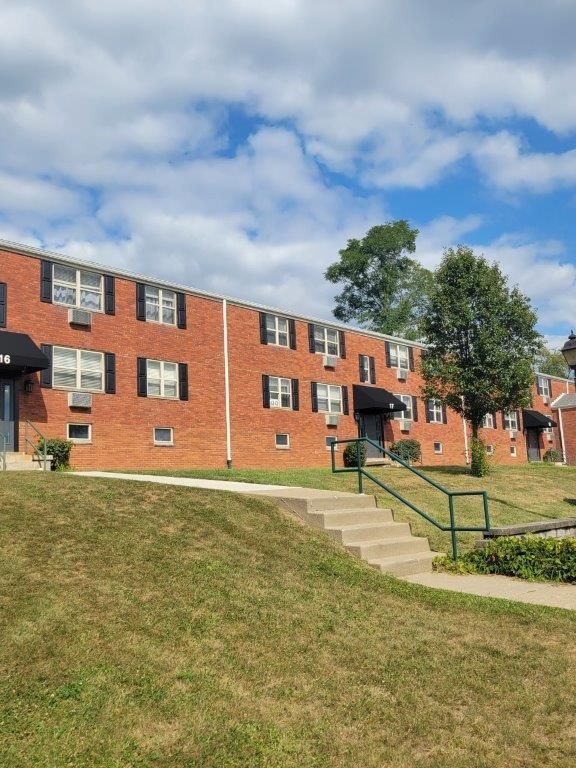 A brick apartment building with stairs leading up to it