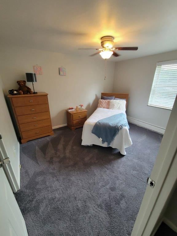 A bedroom with a single bed and a ceiling fan