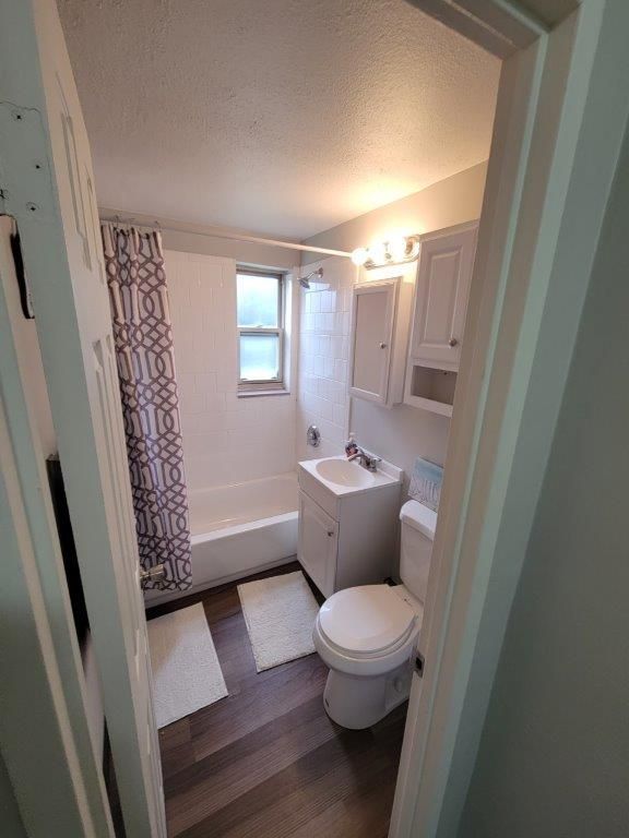 A bathroom with a toilet , sink , and bathtub.