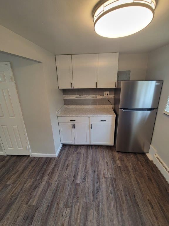 A kitchen with stainless steel appliances and wooden floors.