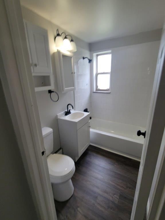 A bathroom with a toilet , sink , and bathtub.