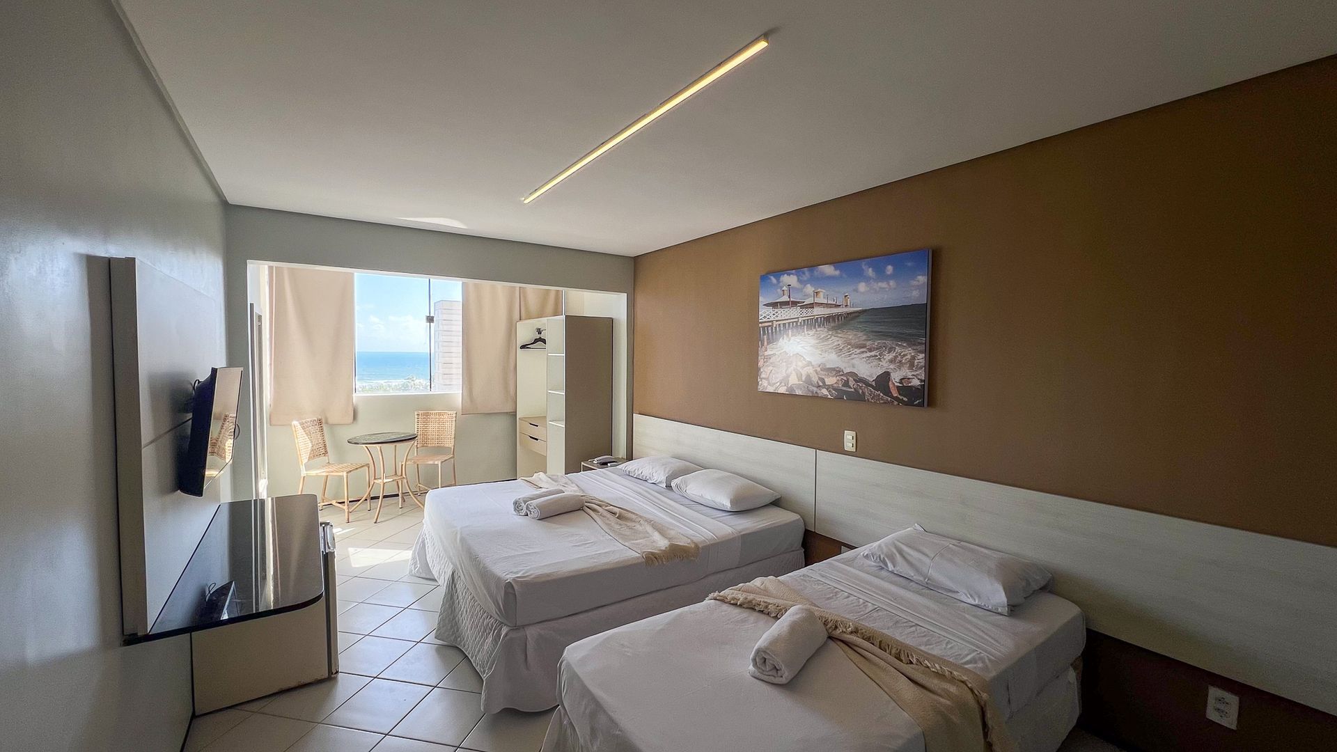 Um quarto de hotel com uma cama grande, uma mesa e cadeiras.-Boreas-Apart-Hotel