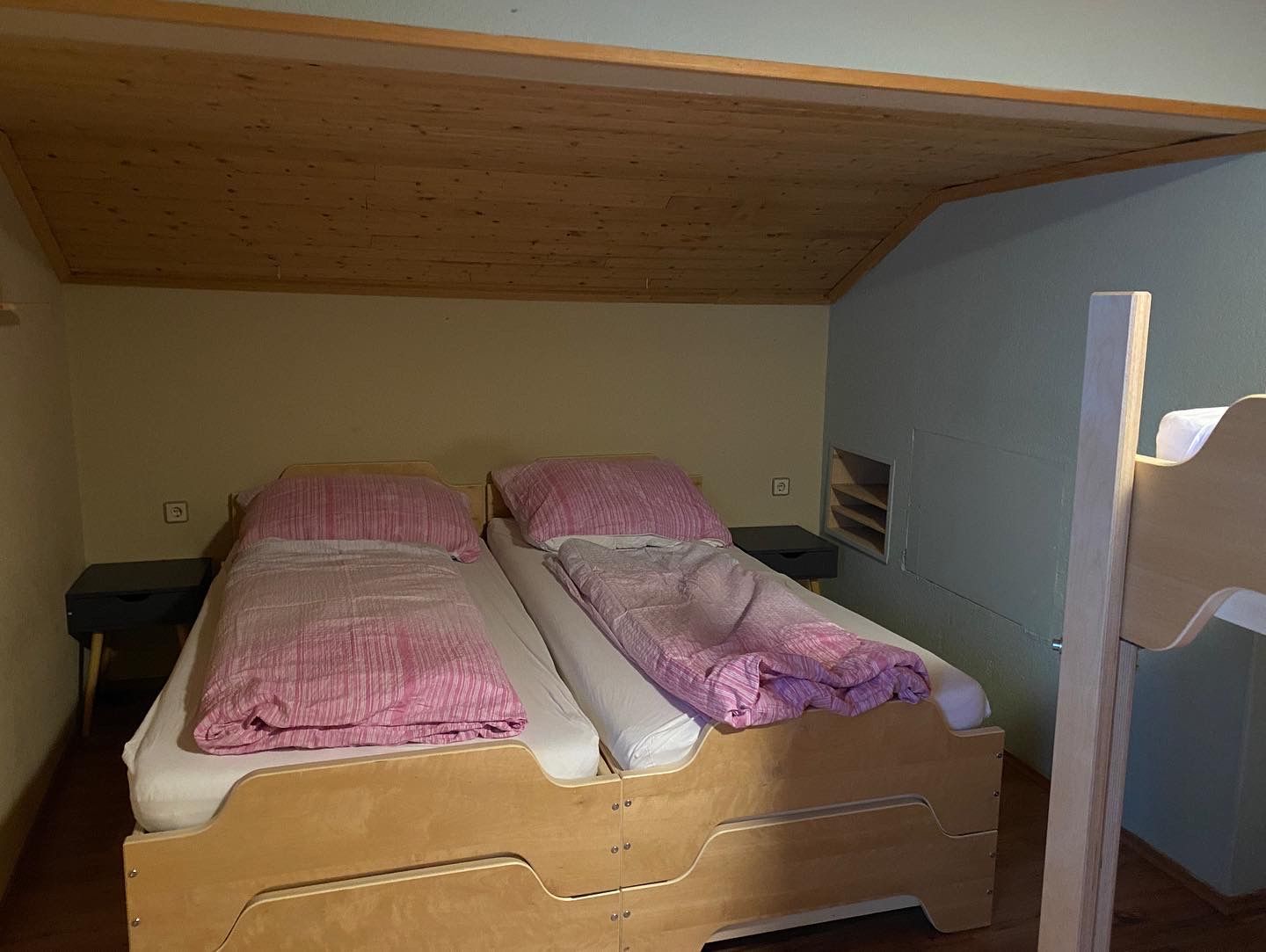 Een slaapkamer met twee bedden en een stapelbed.