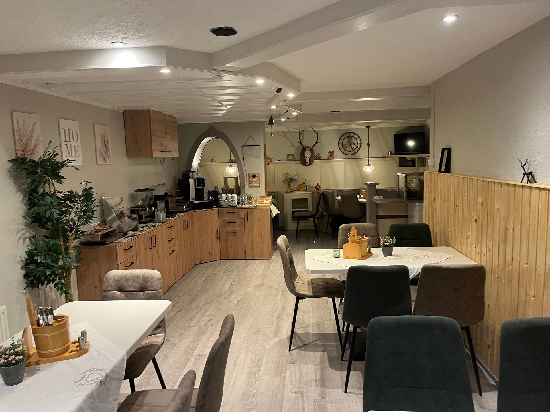 Interieur van een café met houten accenten, tafels, stoelen en decoratieve elementen.