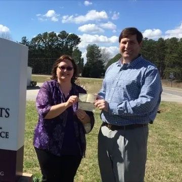 Man and Woman Holding a Check — Lake Wylie, SC — Mayday Project