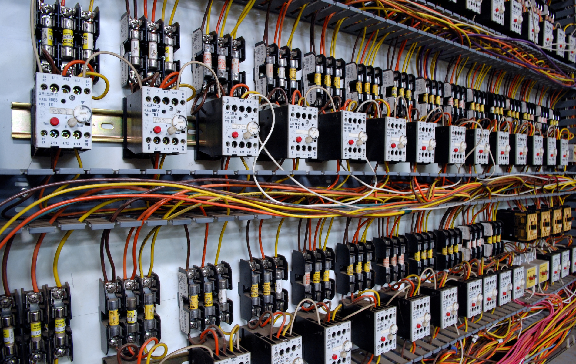 A wall filled with lots of wires and electrical boxes