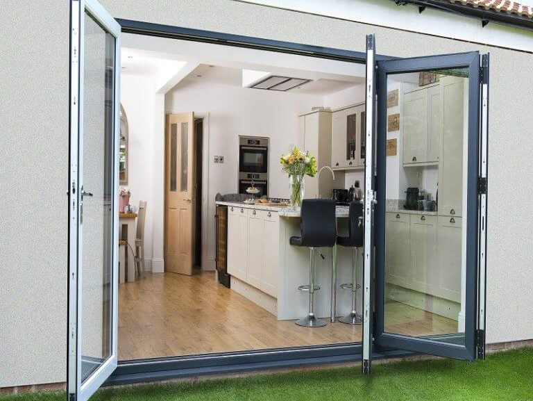 A kitchen with bifold anthracite glass doors that are open