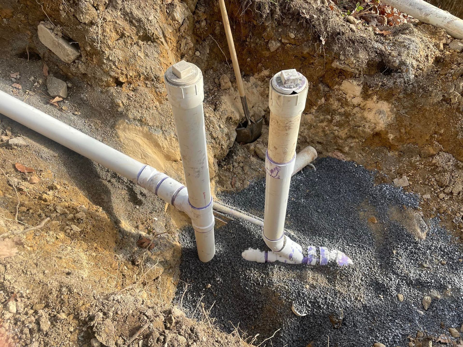 A couple of pipes are sitting in the dirt.