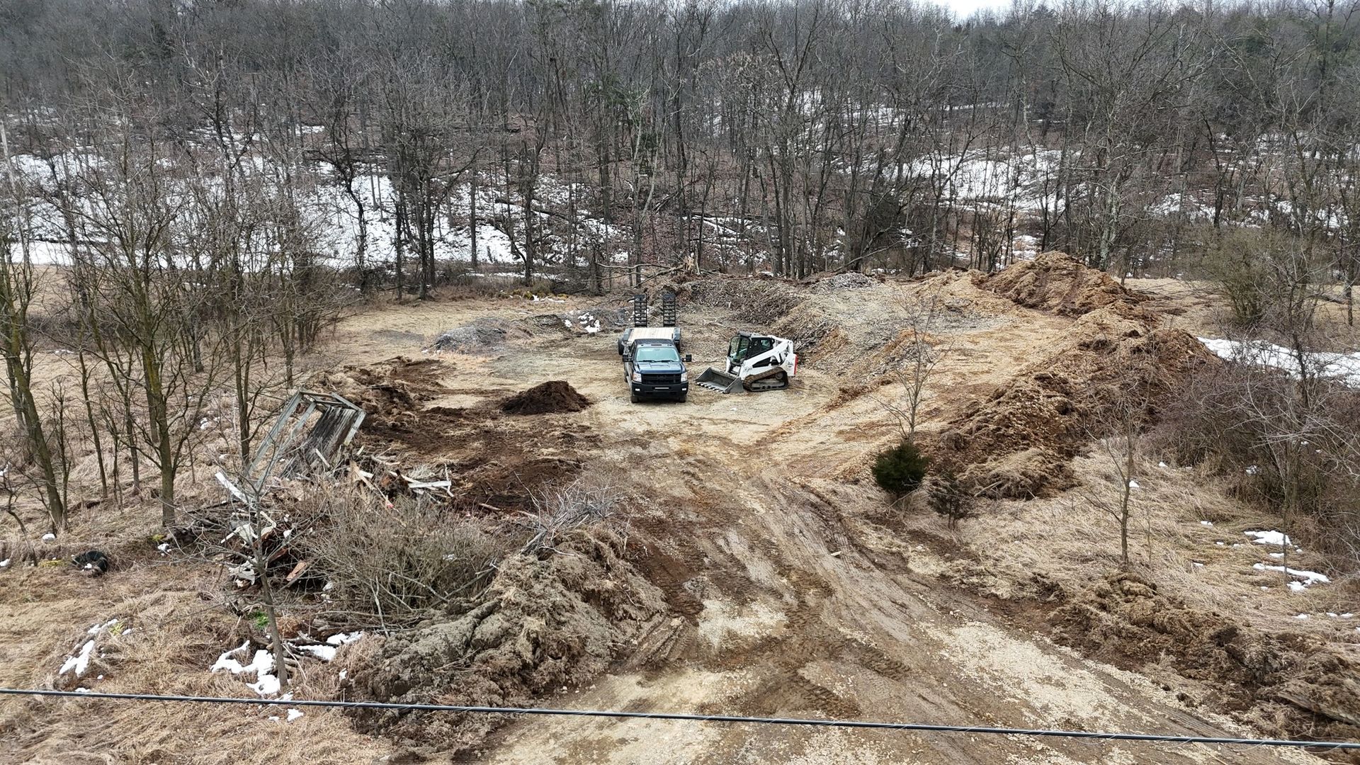 An aerial view of a dirt road in the middle of a forest.