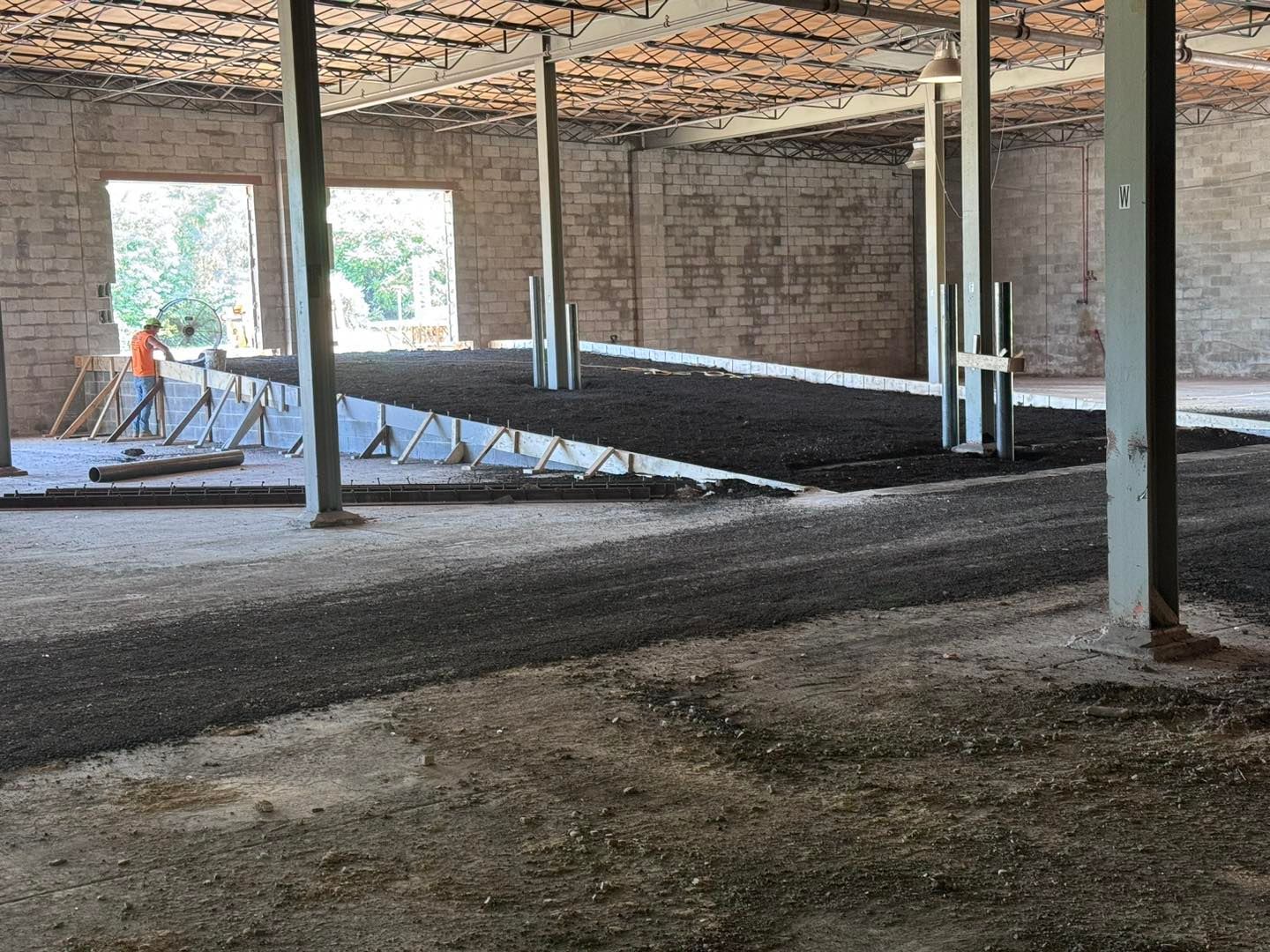 A man is standing in the middle of a building under construction.