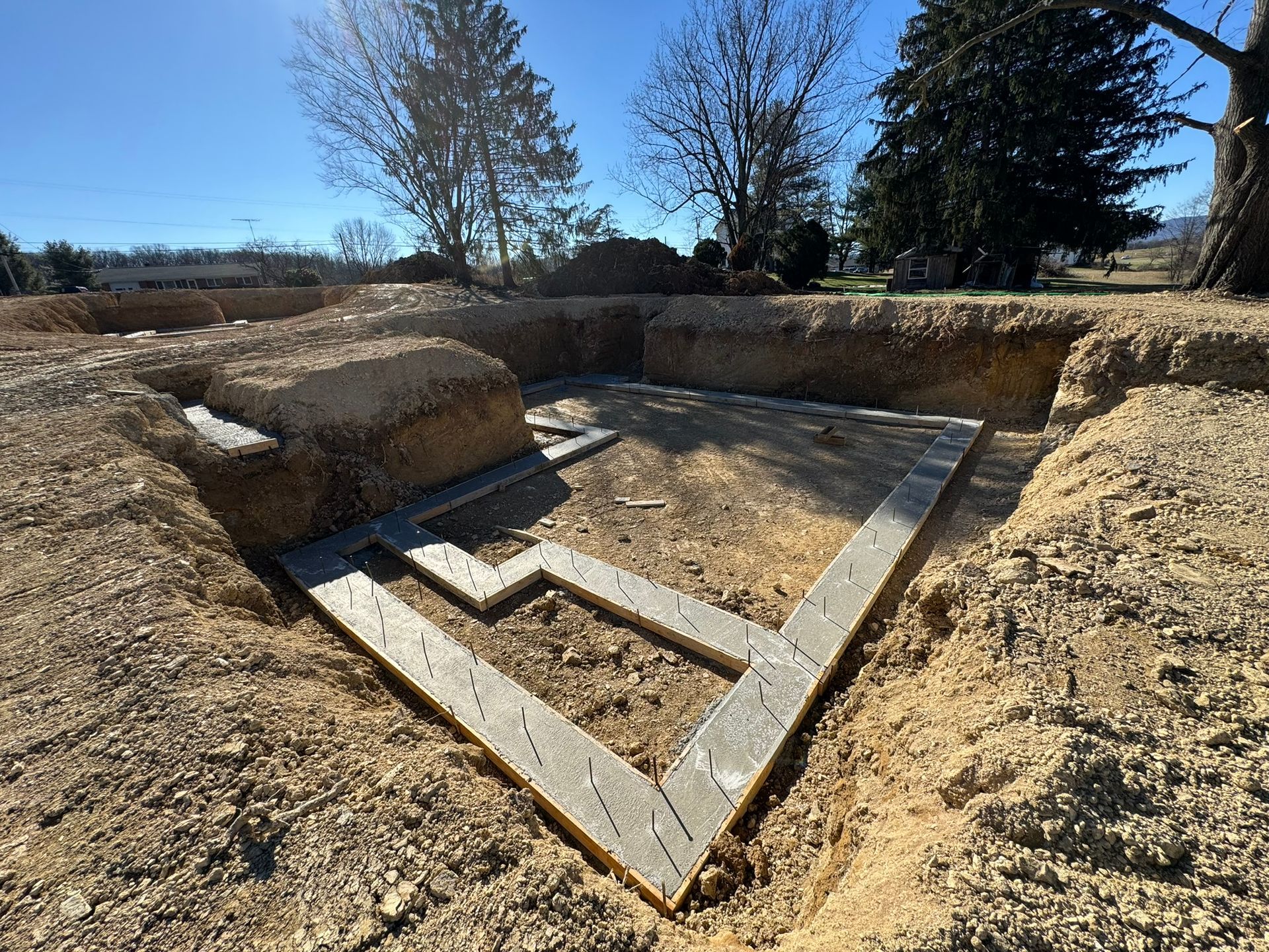 A bulldozer is digging a hole in the ground to install a pipe.
