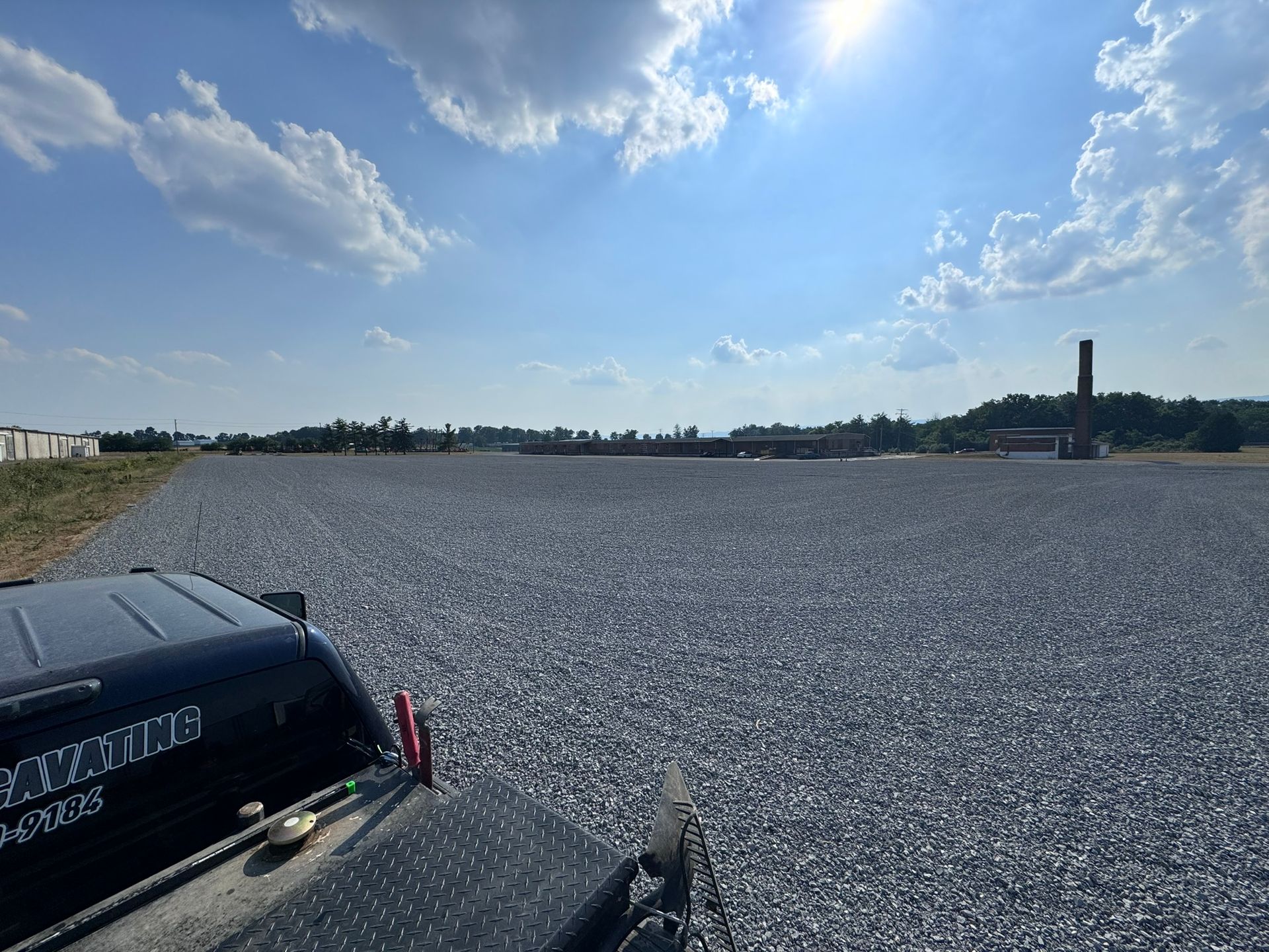 A gravel driveway is being built in front of a house.