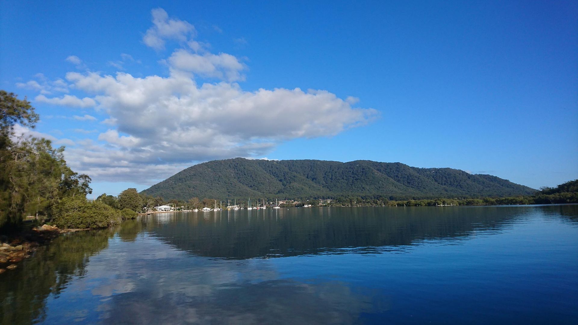 A Lake With A Mountain In The Background And Trees On The Shore — Brett Hall Floorsanding in Laurieton, NSW
