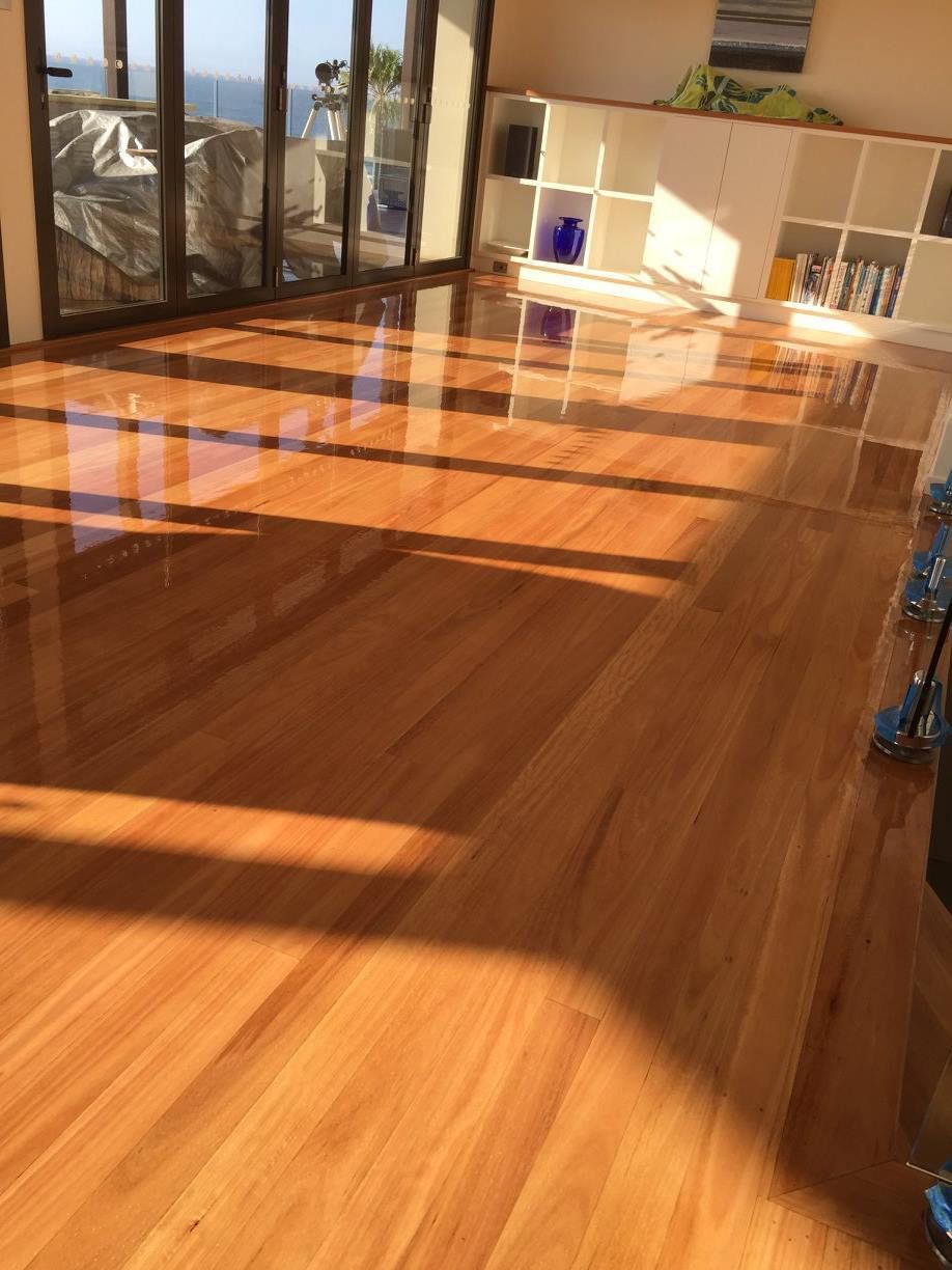 A Living Room With A Wooden Floor And A Lot Of Windows — Brett Hall Floorsanding in Taree, NSW