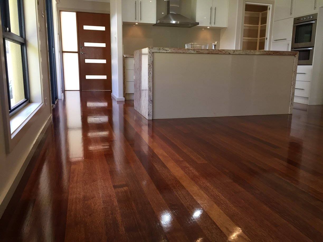A Kitchen With A Wooden Floor And White Cabinets — Brett Hall Floorsanding in Taree, NSW