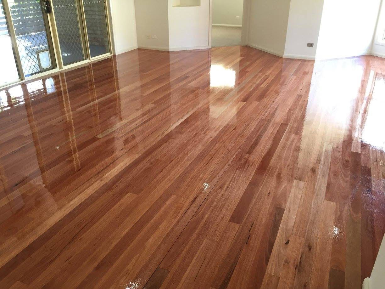 A Living Room With A Wooden Floor And Sliding Glass Doors — Brett Hall Floorsanding in Laurieton, NSW