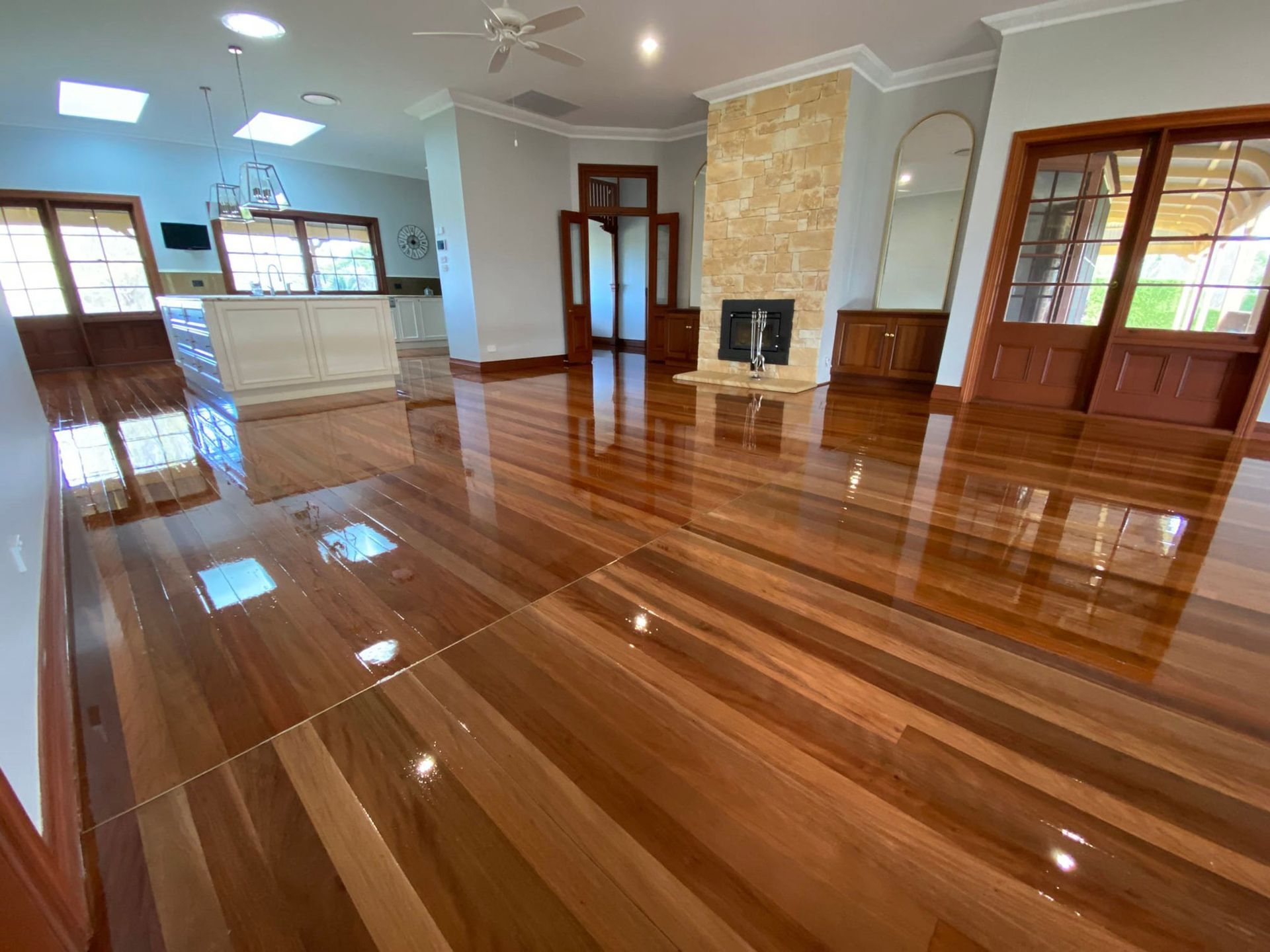A Living Room With A Hardwood Floor And A Fireplace — Brett Hall Floorsanding in Port Macquarie, NSW