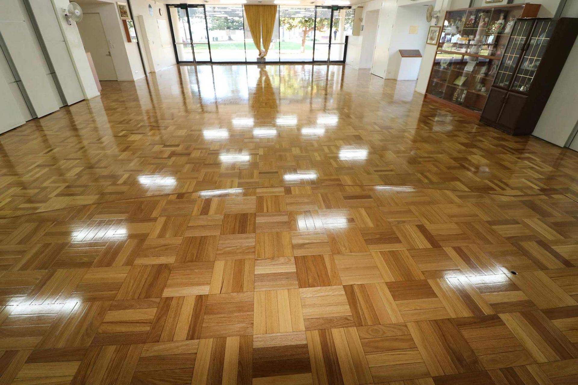 A Large Room With A Wooden Floor And Lots Of Windows — Brett Hall Floorsanding in Kempsey, NSW