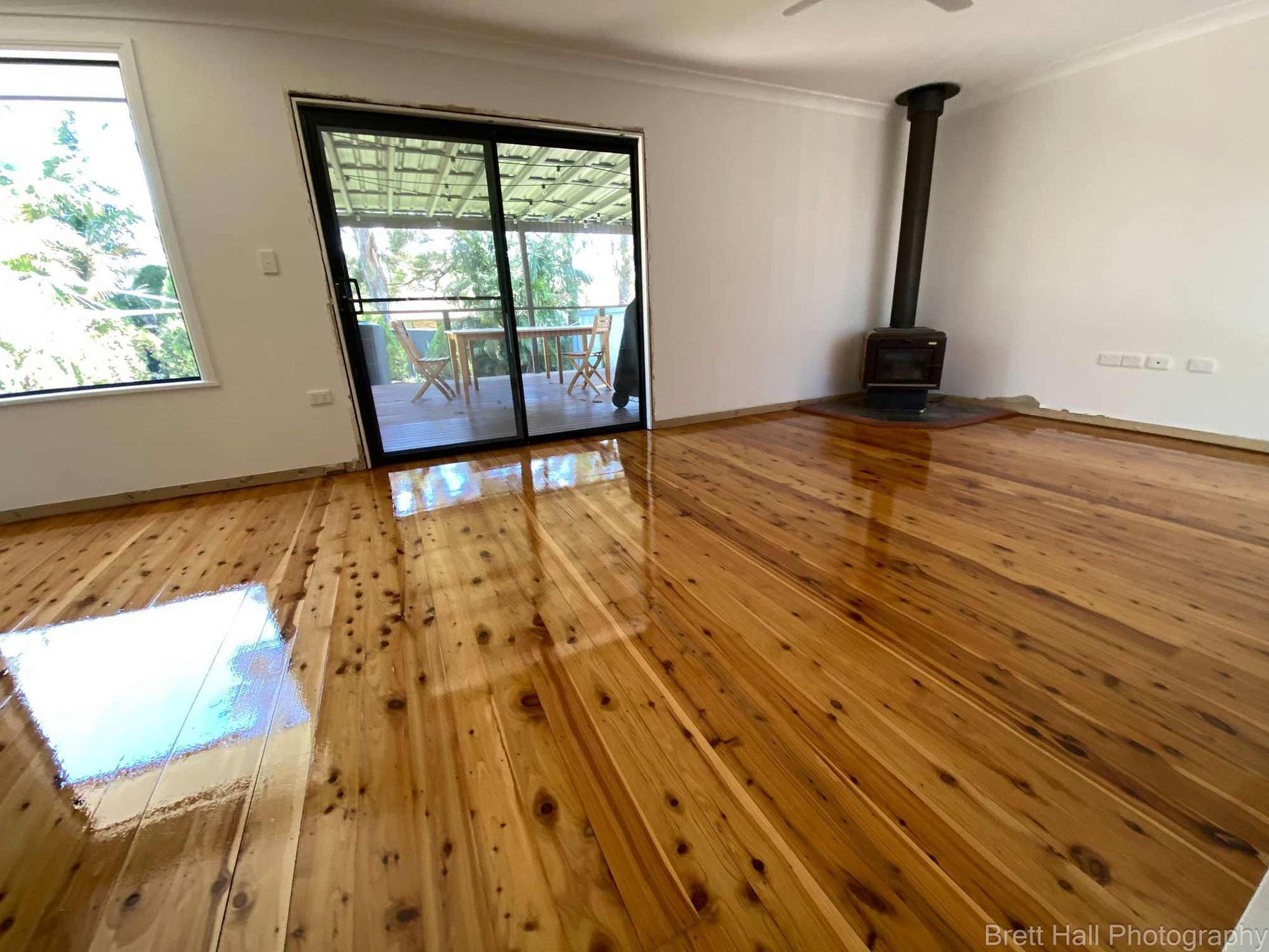 A Living Room With A Wooden Floor And A Fireplace — Brett Hall Floorsanding in Port Macquarie, NSW