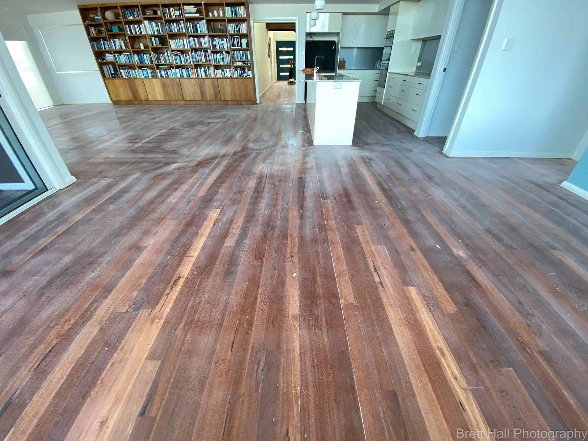A Living Room With A Wooden Floor And A Bookshelf — Brett Hall Floorsanding in Port Macquarie, NSW