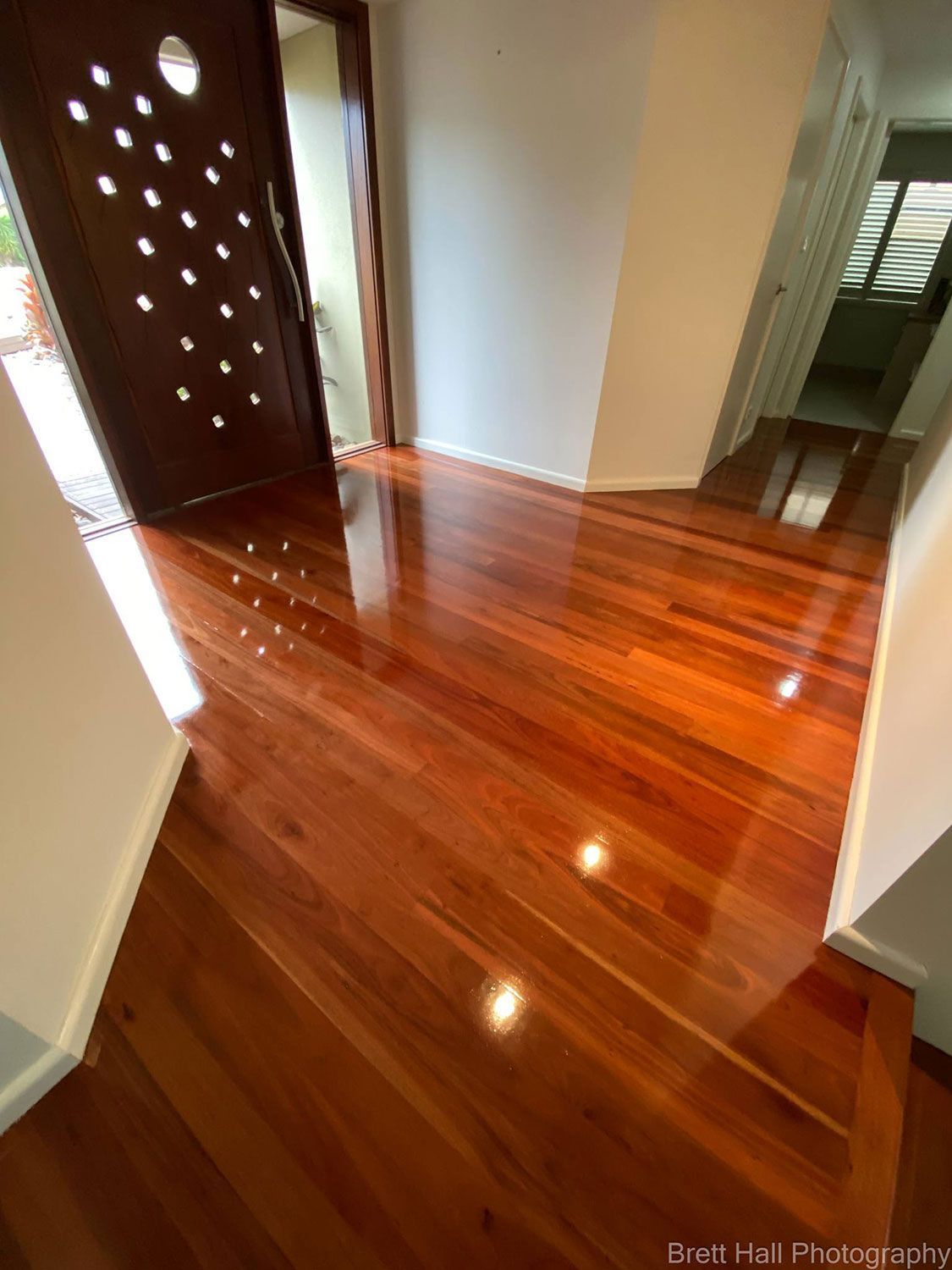 A Hallway With A Wooden Floor And A Door — Brett Hall Floorsanding in Port Macquarie, NSW