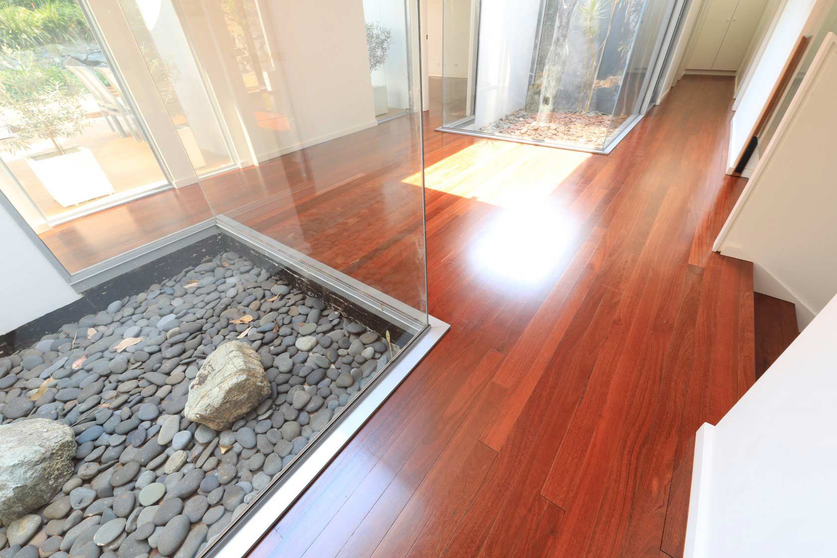 A Polished Wooden Floor With A Rock In The Middle Of It — Brett Hall Floorsanding in Taree, NSW