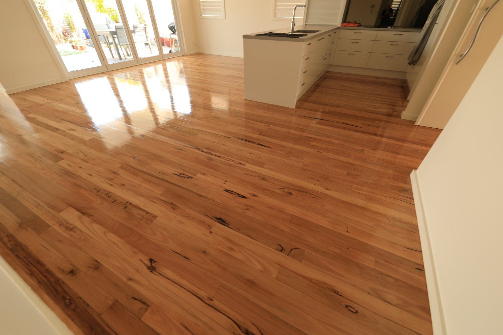 A Kitchen With A Wooden Floor And Sliding Glass Doors — Brett Hall Floorsanding in Wauchope, NSW