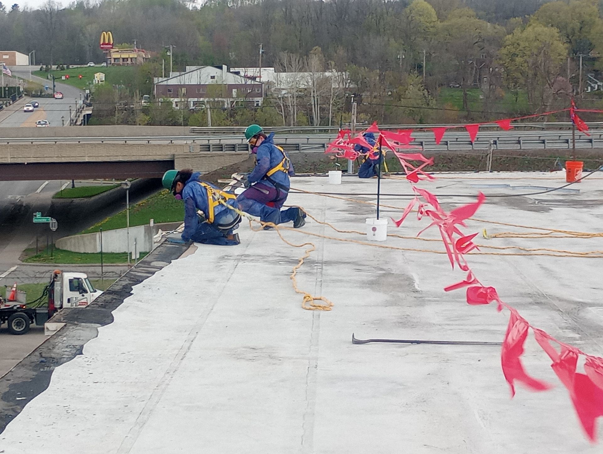 Two MP Environmental Services employees on the roof of a commercial building performing remediation services