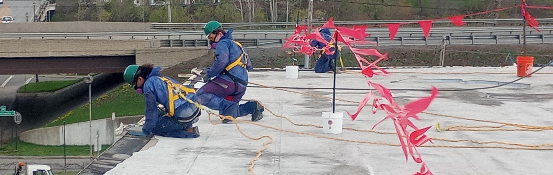 Employees working on top of a building known for Asbestos, surveying the property to decide the best solution.