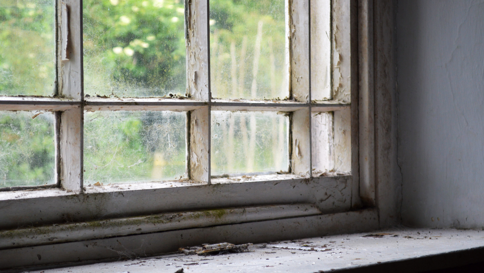 A dirty window with old PCB caulking 