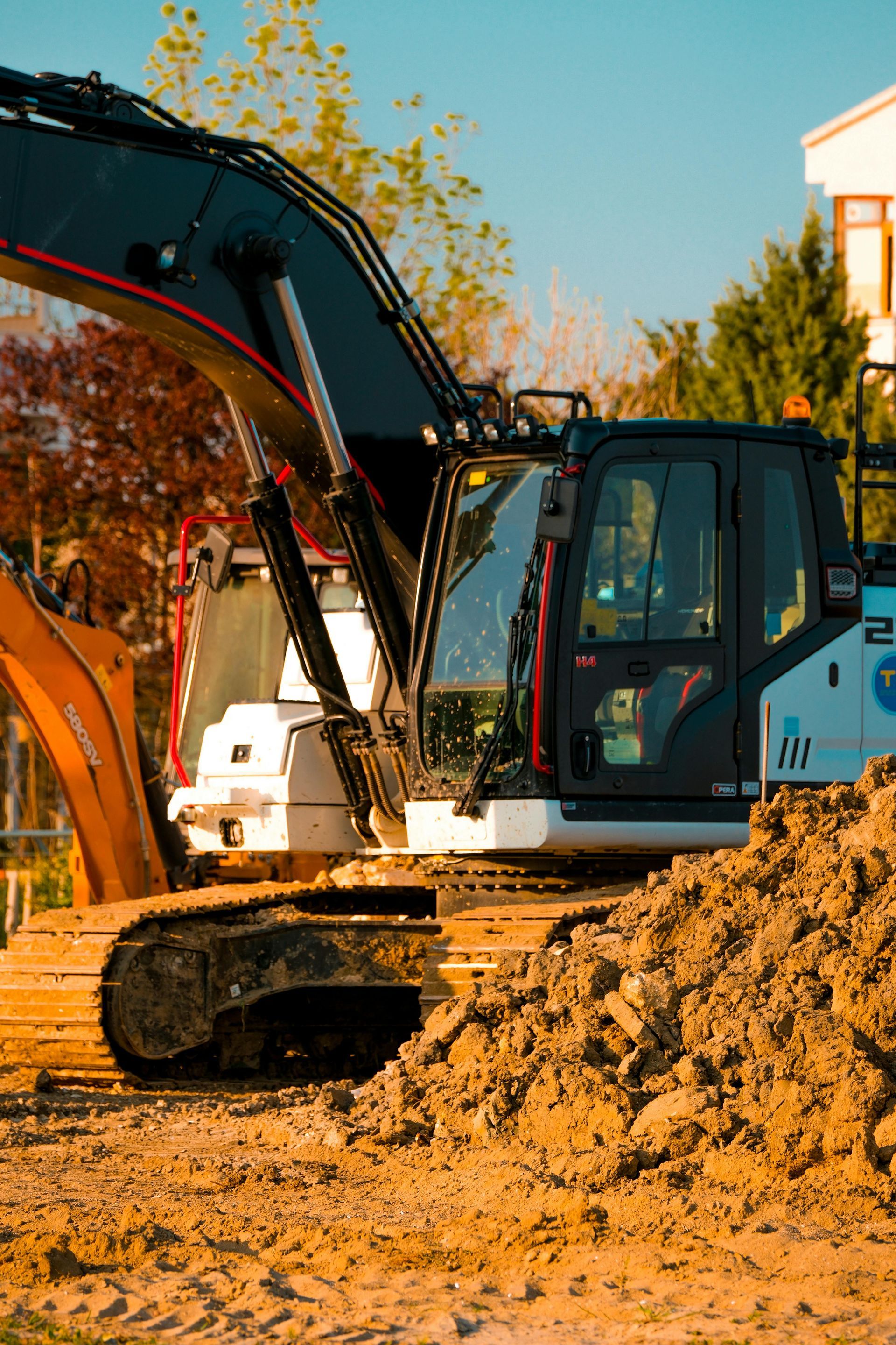 Large Escavator at a construction site among piles of dirt.