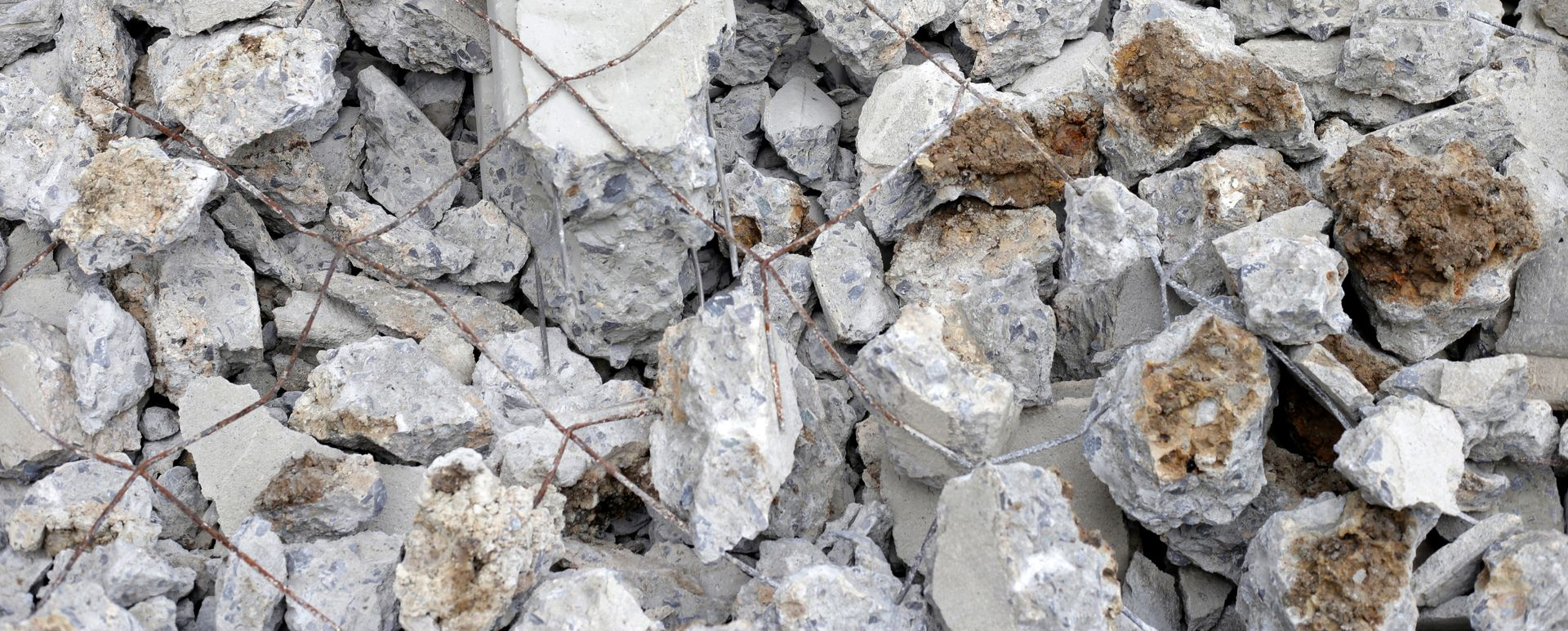 Pile of broken concrete debris with exposed rebar.