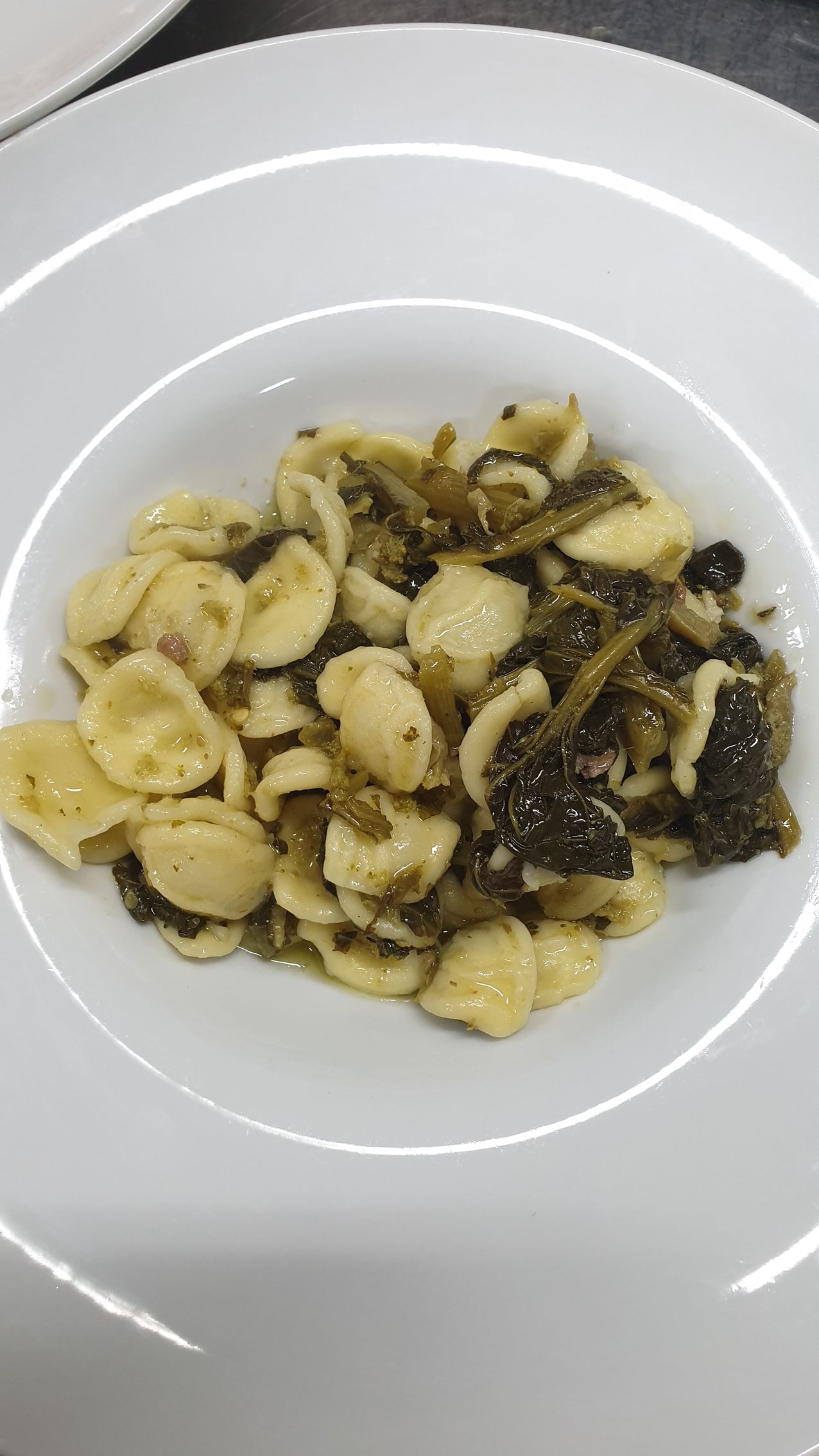 Orecchiette con verdure in una ciotola bianca.