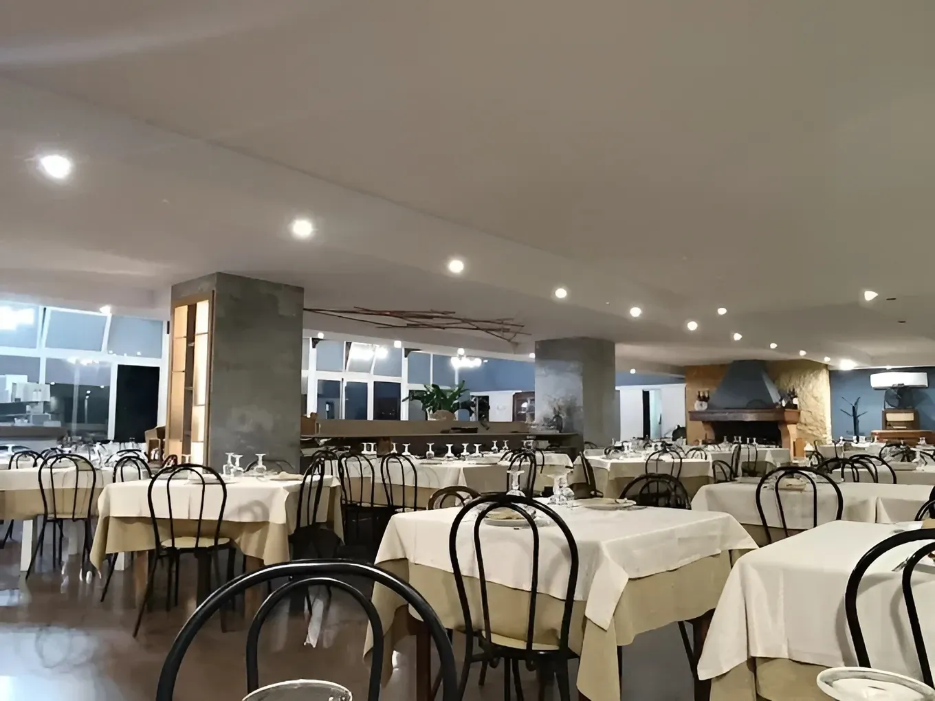 Interno di un ristorante con tavoli apparecchiati per la cena.