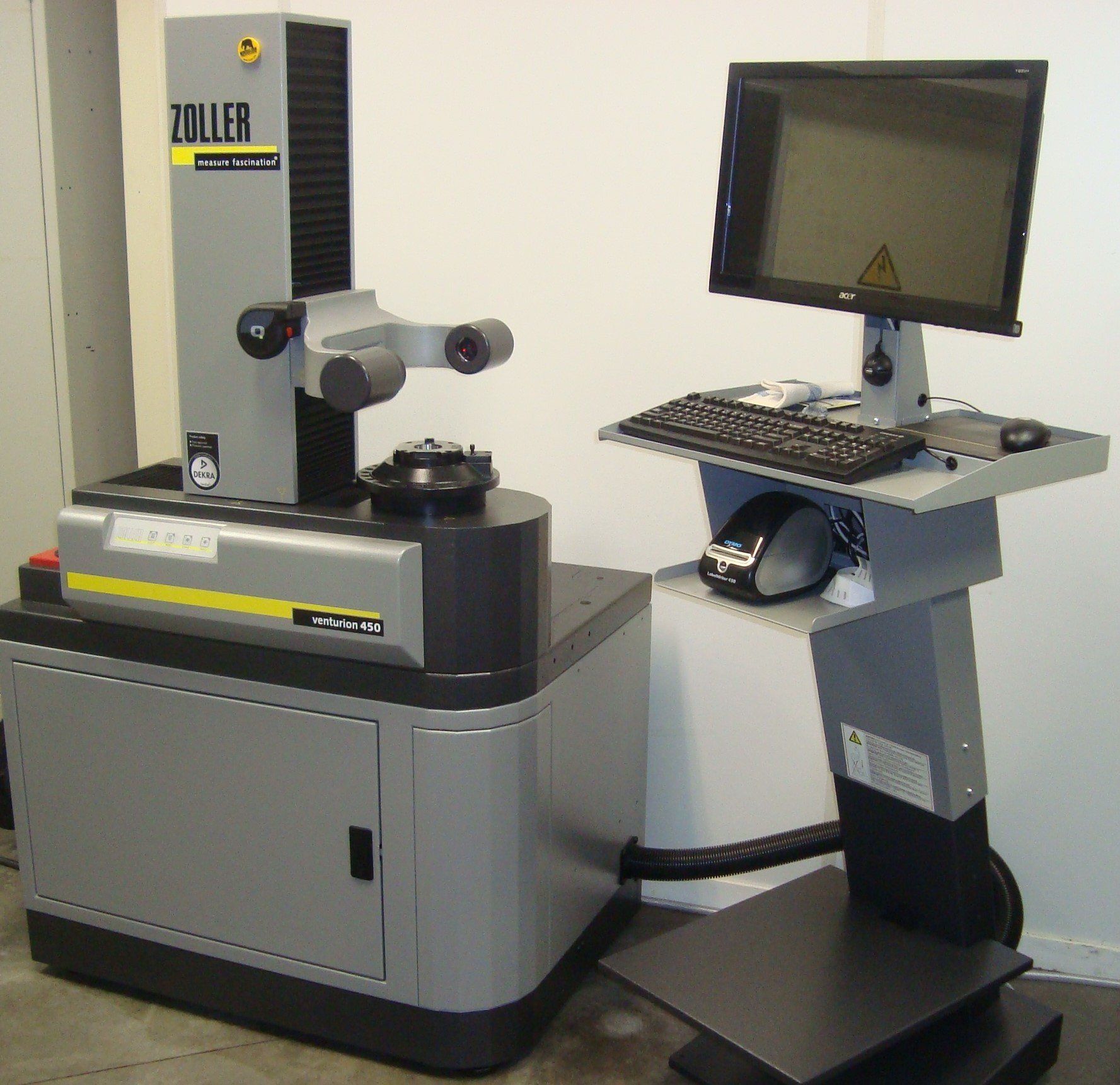 Een tondeuse staat naast een computer op een standaard