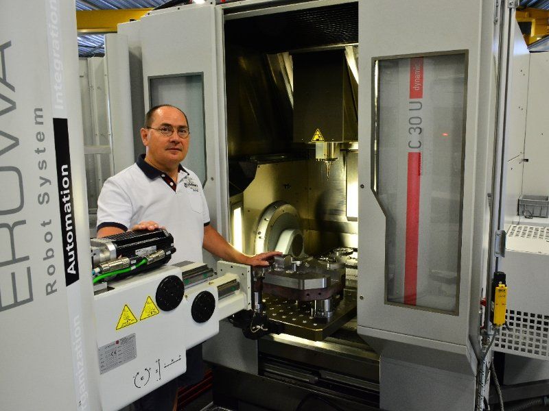 Een man staat voor een machine die robotsysteem zegt