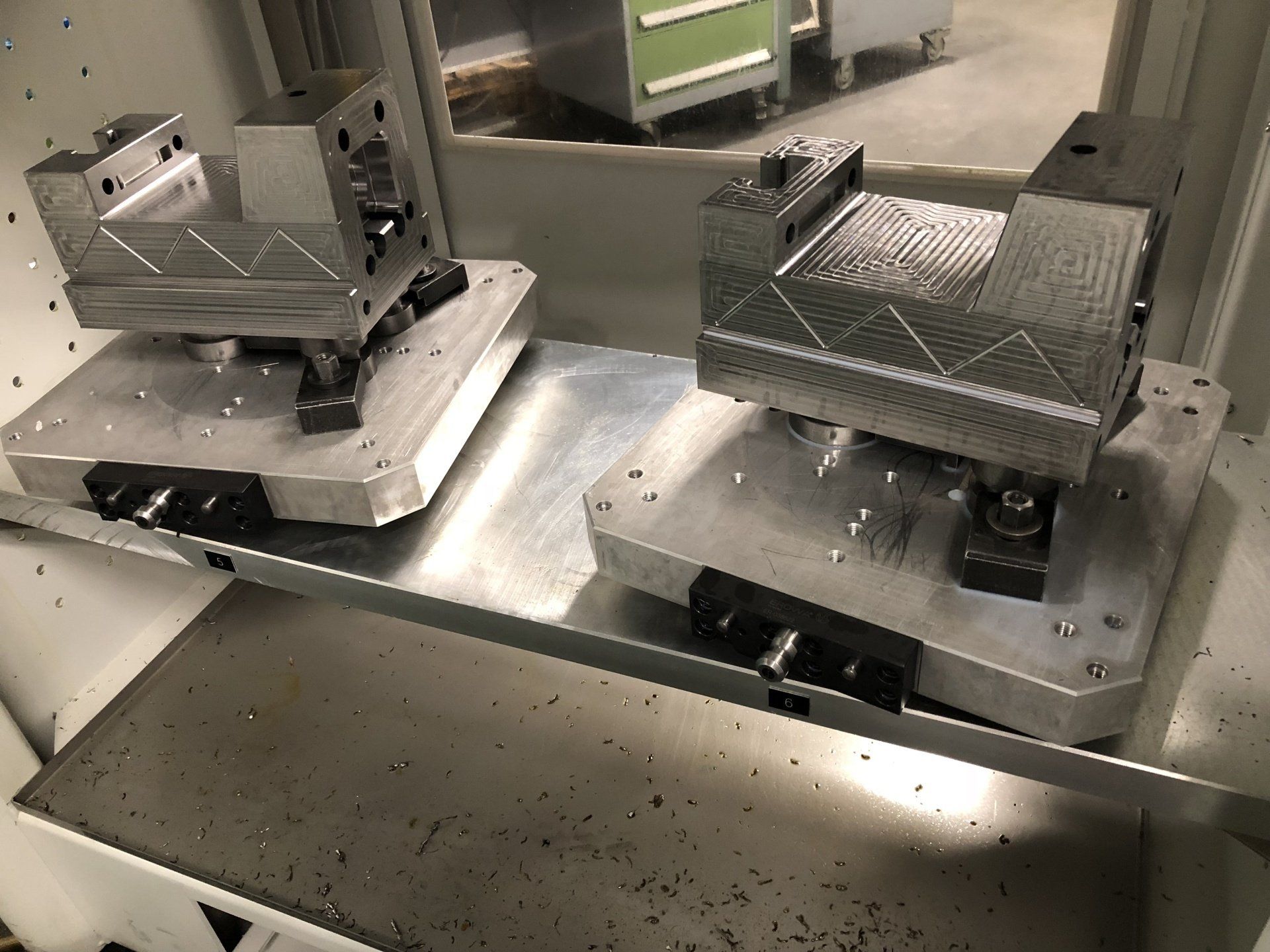 Twee bankschroefhouders staan ​​bovenop een metalen plank.