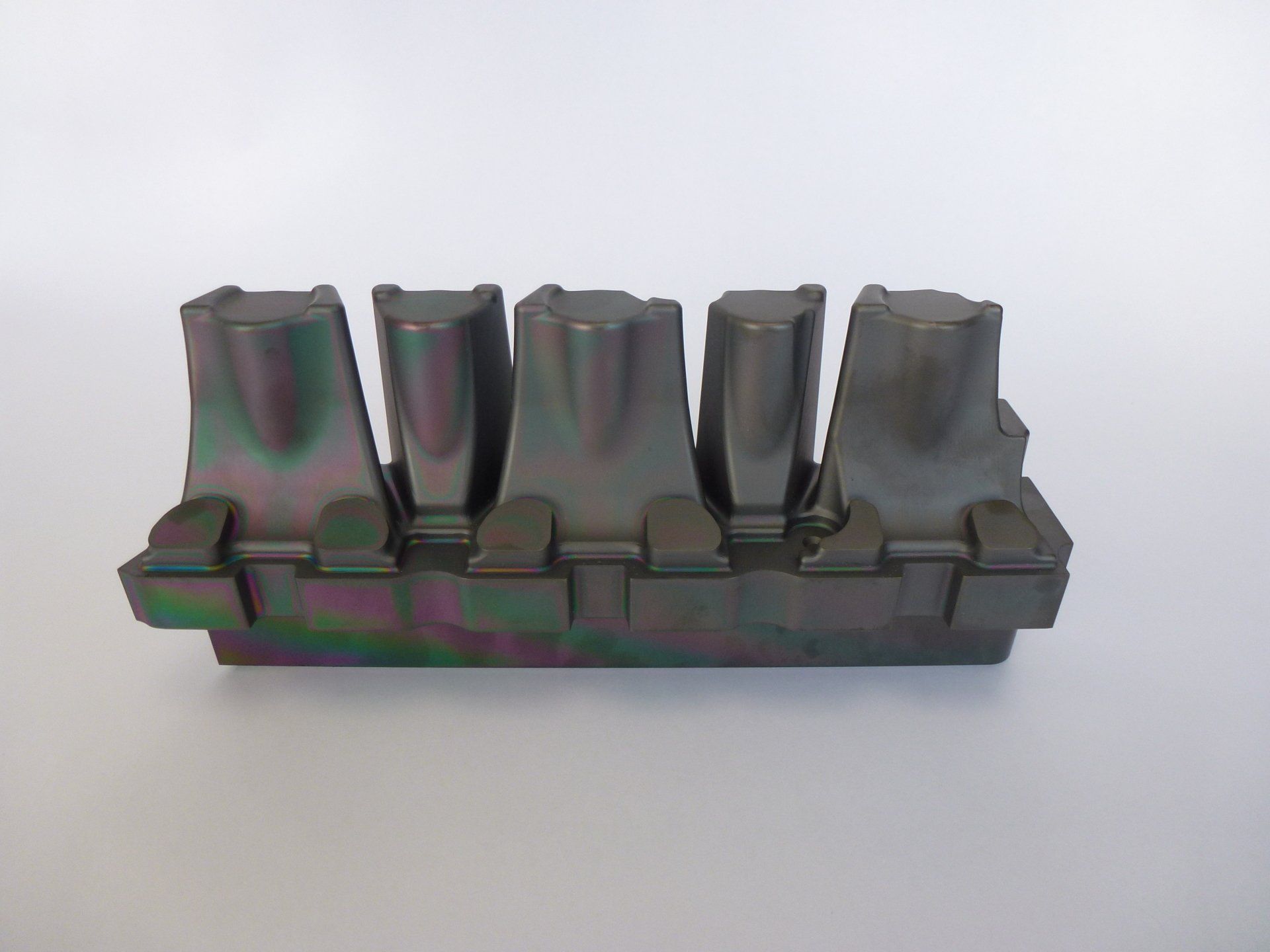 Een rij metalen stukken die op elkaar liggen op een wit oppervlak.